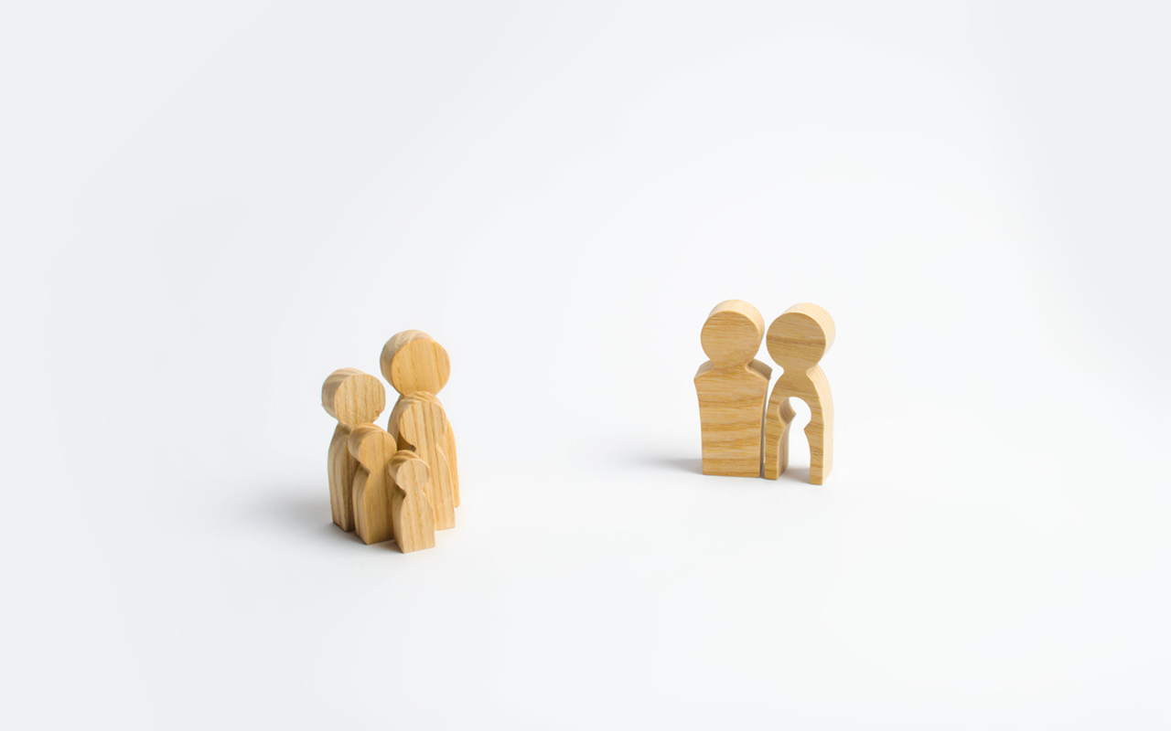 wooden cut out people representing a family and the hole left by infertility